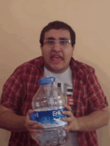 a man in a plaid shirt is holding a erik water bottle