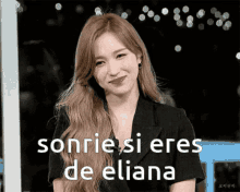 a woman in a black jacket smiles with the words sonrie si eres de eliana below her