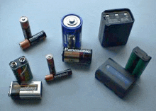 a variety of batteries are sitting on a table .