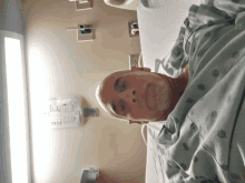 a man in a hospital gown is laying in a bed