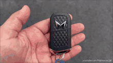 a person is holding a car key in their hand with youtube.com/namastecar on the bottom