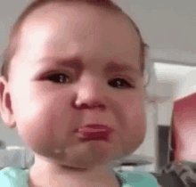 a baby is crying with tears coming out of his eyes .