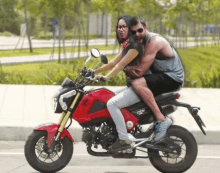 a man and a woman are riding a motorcycle that says honda on it