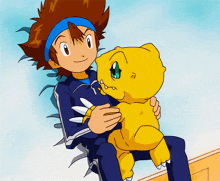 a boy in a blue jacket is holding a yellow animal