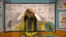 a man is covered in yellow slime in front of a board with math equations written on it