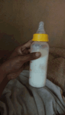 a person is holding a baby bottle that is full of milk