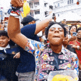 a man holds up a banana in front of a crowd with a wristband that says nyc all over it