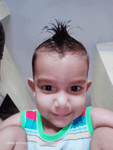 a baby with a mohawk is smiling for the camera with the words oppo f11 pro on the bottom right