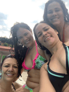 four women in bikinis are posing for a photo