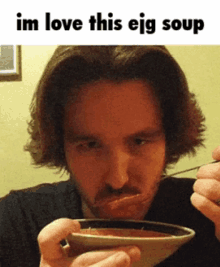 a man is eating a bowl of soup with a caption that says im love this ejg soup