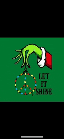 a grinch hand is holding a peace sign hanging from a christmas tree .