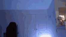 a dark room with a blue light shining on the door