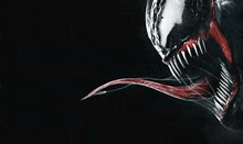 a close up of venom 's face with its tongue hanging out on a black background .