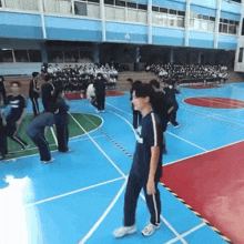 a group of people are standing on a basketball court with one wearing a shirt that says ' a ' on the front