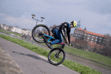 a man is doing a trick on a bike with the word maxxis on the front wheel