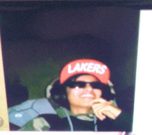 a person wearing a lakers hat with sunglasses on