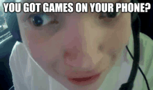 a close up of a person 's face with the words " you got games on your phone " below it