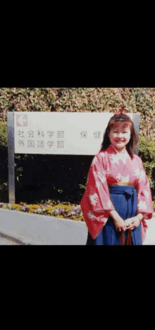 a woman in a red kimono stands in front of a sign that says k3