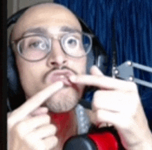 a man wearing headphones and glasses is making a funny face .