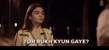 a woman in a yellow jacket is talking to a man in a dark room and says `` toh rukh kyun gaya ? ''