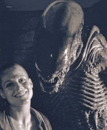 a woman standing next to a statue of a monster