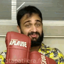 a man wearing a pair of red boxing gloves that say aplause