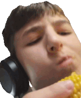 a man wearing headphones is eating corn on the cob