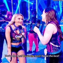 a female wrestler is talking into a microphone while another woman says you 're the best you 're the best