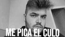 a black and white photo of a man with a beard and the words `` me pica el culo '' on his face .