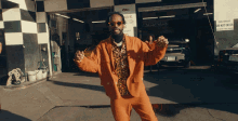 a man in an orange suit is standing in front of a garage with a sign that says do not enter