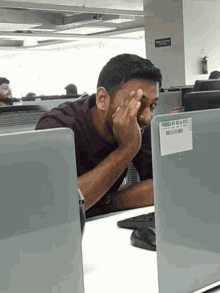 a man sitting at a desk with a laptop that has a sticker on it that says ' photo 01 01 8 03 '