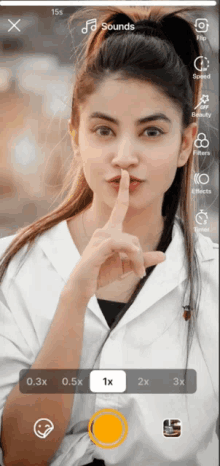 a woman holds her finger to her lips in front of a screen that says sounds on it