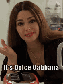 a woman holding a toaster that says it 's dolce gabbana on it