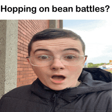 a man wearing glasses and a black jacket is standing in front of a brick wall with the words hopping on bean battles below him