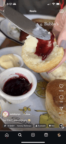 a person is spreading jelly on a biscuit with a knife