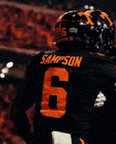 a football player wearing a black jersey with the number 6