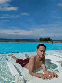 a young man laying on a raft in a pool