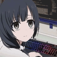 a girl is sitting in front of a computer keyboard and a monitor .