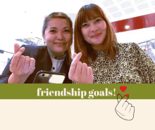 two women are making a heart shape with their fingers and the words friendship goals below them