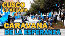 a group of people holding blue flags are walking down a street in a city .