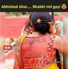 a woman is wearing a red blouse with the name abhishek ki dulhan on it .