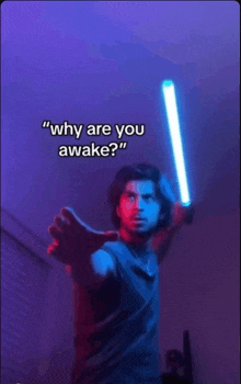 a man is holding a light saber with the words " why are you awake " above him