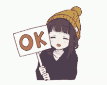 a girl holding a sign that says ok on it