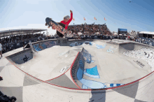 a skateboarder flies through the air at a vans park event