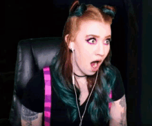 a woman with a surprised look on her face is wearing headphones and a choker .