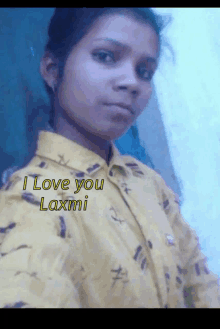 a girl in a yellow shirt with the words " i love you laxmi " on it