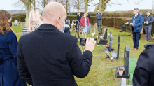 a man takes a picture of a cemetery with a cell phone