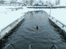 a person is swimming in a body of water with a building in the background that says ' hotel ' on it