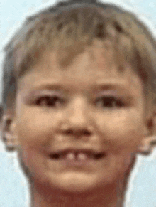 a close up of a young boy 's face with a blue background .