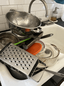 a dirty kitchen sink with a grater on top